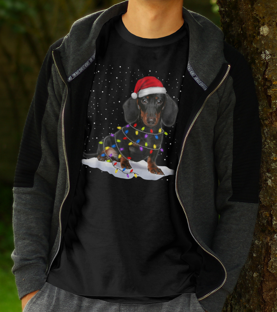 Dachshund Santa Hat Wrapped In Christmas Tree Lights In Snow With Falling Snowflakes T-Shirt