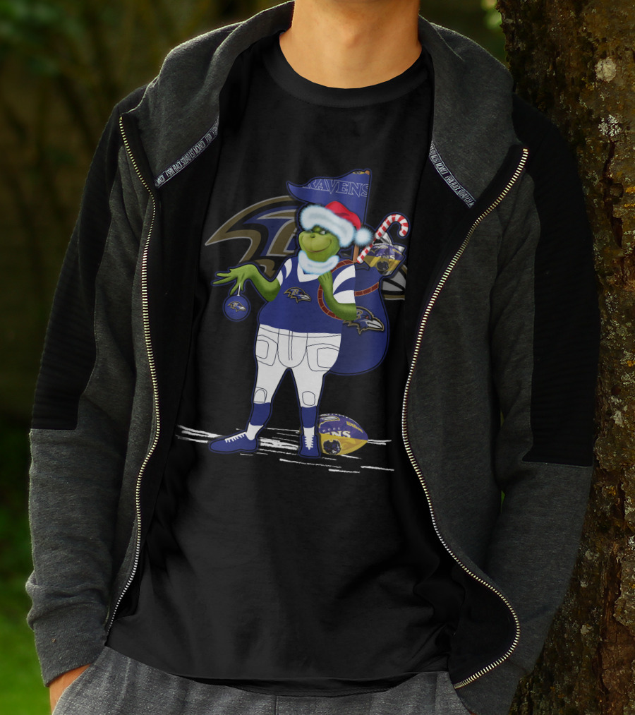 Grinch Santa Holding Candy Cane Bag And Baltimore Ravens Football In Ravens T-Shirt