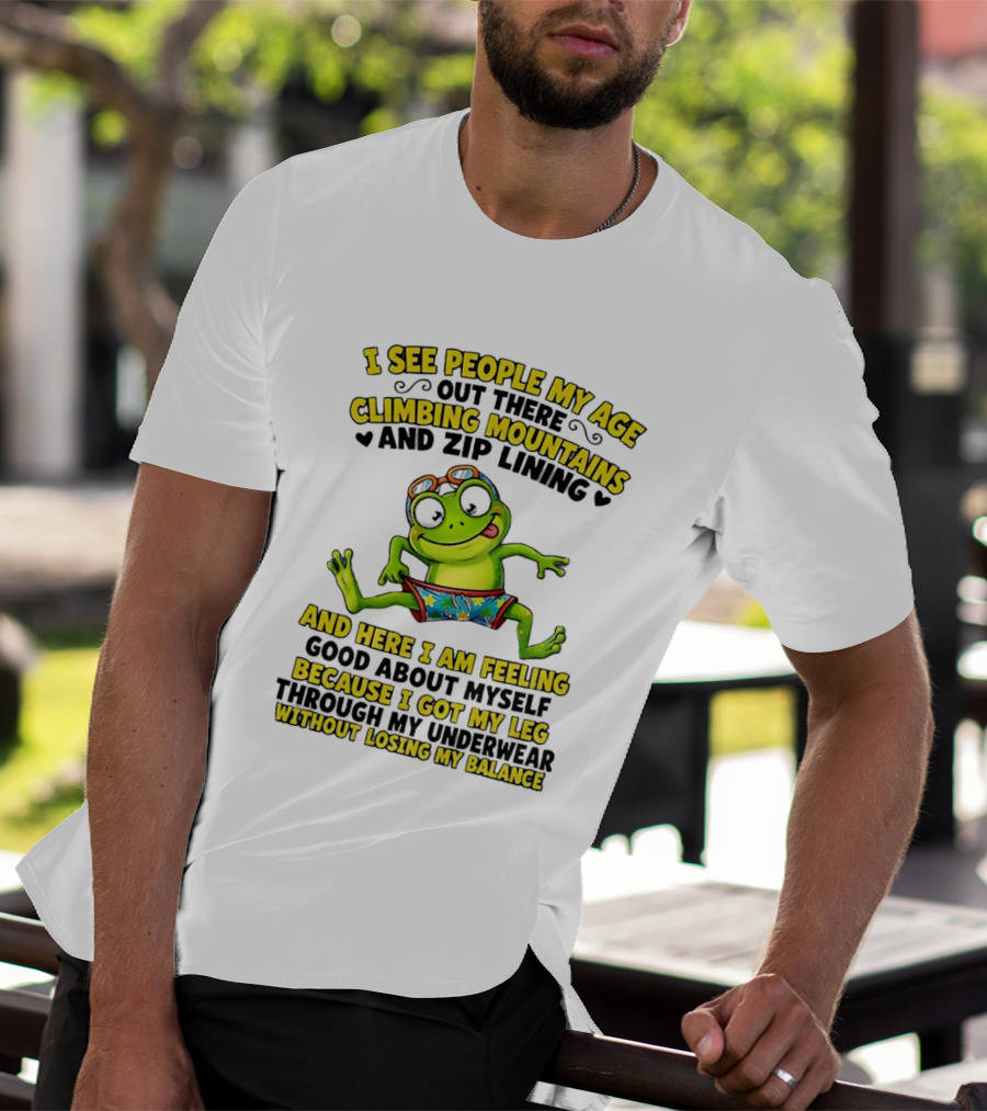 I See People My Age Climbing Mountains And Zip Lining Cartoon Frog Feeling Good Without Losing Balance T-Shirt