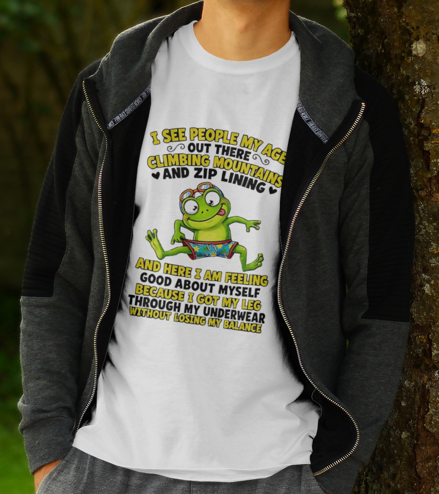 I See People My Age Climbing Mountains And Zip Lining Cartoon Frog Feeling Good Without Losing Balance T-Shirt