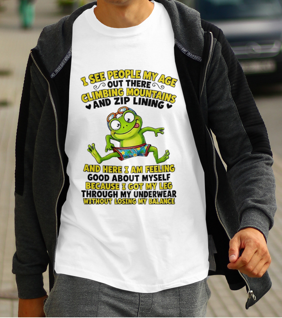 I See People My Age Climbing Mountains And Zip Lining Cartoon Frog Feeling Good Without Losing Balance T-Shirt