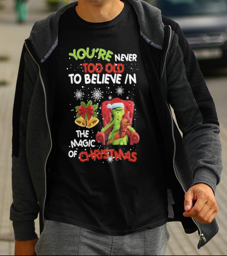 YOU'RE NEVER TOO OLD TO BELIEVE IN THE MAGIC OF CHRISTMAS GRINCH WITH MAX SITTING IN CHAIR SNOWFLAKES HOLIDAY BELLS AND BOW T-Shirt