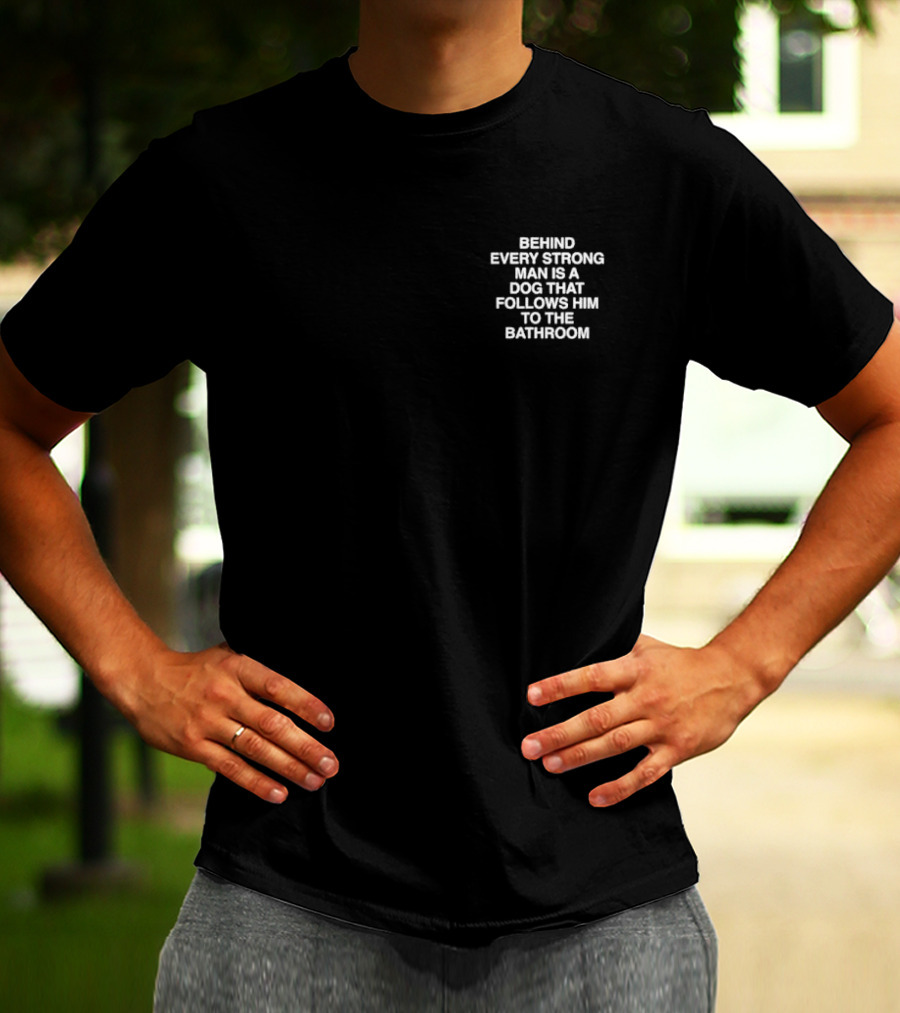 BEHIND EVERY STRONG MAN IS A DOG THAT FOLLOWS HIM TO THE BATHROOM T-Shirt